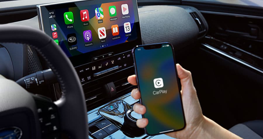 Apple CarPlay running on a car's touchscreen with an iPhone showing the CarPlay logo